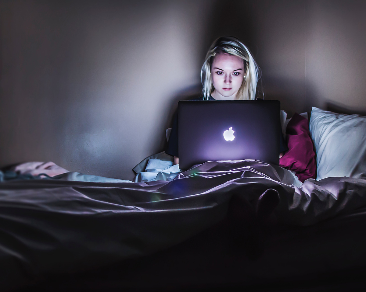 girl using computer in bed